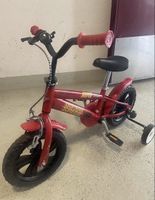 Bici per bambini rossa con rotelle di sostegno