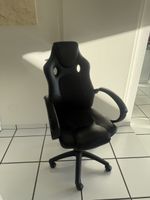 Gaming Stuhl schwarz mit Gebrauchsspuren an Armlehnen