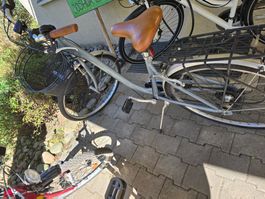 Bicicletta da città grigia con cestino in buono stato