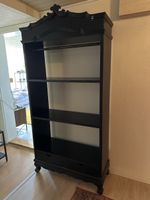 Schwarzes Regal mit Verzierungen aus Holz