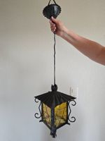 Vintage Hängelampe, Metall und Glas, gelbliches Licht.