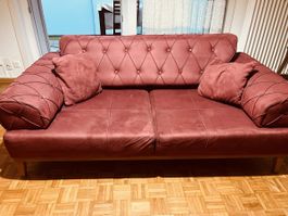 Sofa in Dunkelrot mit Knopfheftung gebrauchter Zustand.