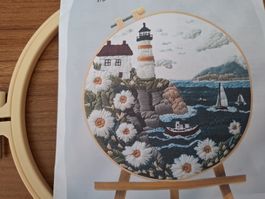 Handgemachte Stickerei "Leuchtturm am Meer" im Rahmen.