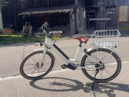 E-bike cream frame with brown saddle and basket
