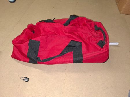 Rote Reisetasche mit Rollen und Schweizer Kreuz