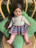 Alte Puppe mit handgestrickter Kleidung