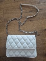 Weisse Umhängetasche mit Kette.