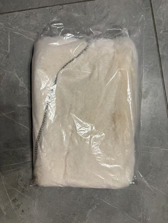Borsa in pelliccia sintetica bianca con catena argentata.