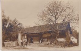 Saubere Ansichtskarte mit altem Bauernhaus und Steinbrunnen.