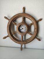 Gouvernail de navire en bois avec horloge murale.