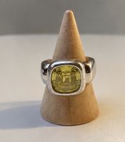 Silberfarbener Ring mit gelbem Stein