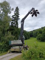 Pneubagger mit Schrottgreifer und Teleskoparm