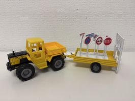 Traktor mit Anhänger und Verkehrsschilder