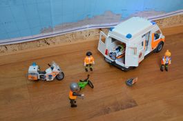 Playmobil-Ambulanzwagen und -motorrad mit Blaulicht