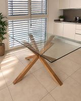Tavolo da pranzo moderno in vetro con base in legno