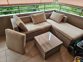 Schöne Rattan-Gartenlounge mit Glastisch