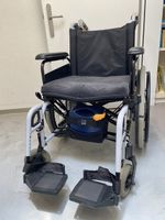Rollstuhl mit Schiebe- und Bremshilfe