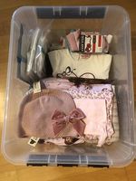 Box mit neuen Kleiderstücken für Mädchen