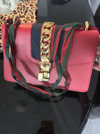 Elegante rote Ledertasche mit goldenen Kettendetails, perfek
