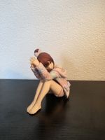 Anime Figur Mädchen sitzend in rosa Jacke