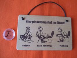 Holzschild, Mann pinkelt im sitzen