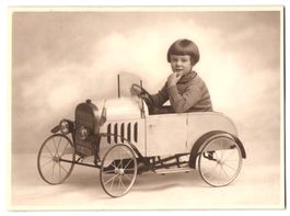 Fotografie niedliches Kind im Tretauto, 
