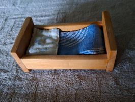 Vintage Puppenhausmöbel, ein Bettchen aus Holz mit Inhalt