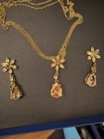 Goldfarbenes Schmuckset mit Blumen und Steinen. Neu.