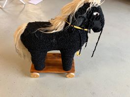 Spielzeugpferd auf Rädern schwarz