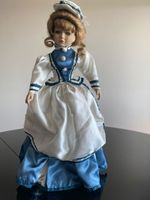 Elegante Vintage-Porzellanpuppe im blau-weissen Kleid