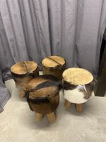 Vier Fellhocker mit Holzbeinen