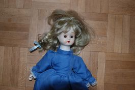 Hübsche antike Porzellanpuppe mit blauem Kleid