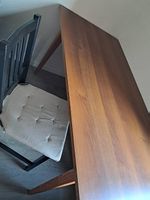Brauner Tisch und zwei Ikea Stühle schwarz