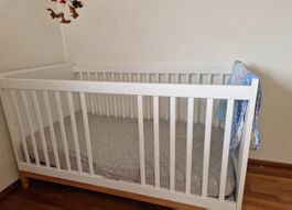 Zeitloses Babybett / Gitterbett in Weiss mit Holzfüssen