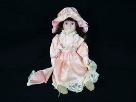 Porzellanpuppe mit rosa Kleidern