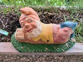 Gartenzwerg liegend beim Lesen