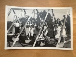Carte postale ancienne, groupe de personnes sur balançoires 
