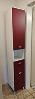 Hochschrank rot/weiss mit 2 Türen und eine Schublade.