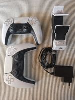 Deux manettes PS5 avec un socle de chargement.