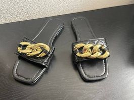 Stylische flache Pantoletten Schwarz mit goldener Kette