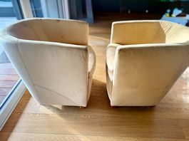 Deux fauteuils "crapaud" en cuir jaune/beige clair