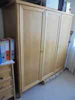 Grosser, gut erhaltener Kleiderschrank aus hellem Holz.