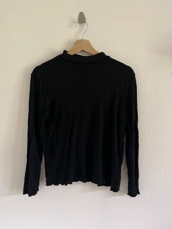 Pull noir avec léger colle roulé