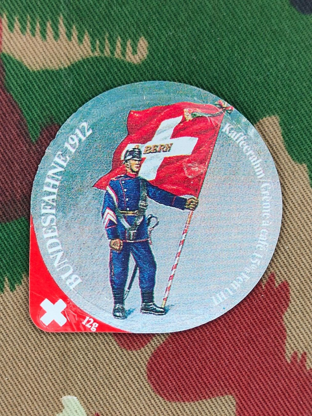 Schweizer Armee Placchette & Badge: Kaffeerahmdeckel BUNDESFAHNE 1912 – Usato da Bauma venduto da SwissMilitaria