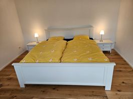 Weisses Doppelbett mit je 2 Bettrosten, Nachttischen, Lampen