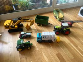 Bagger, Traktor mit Anhänger und Feuerwehrauto