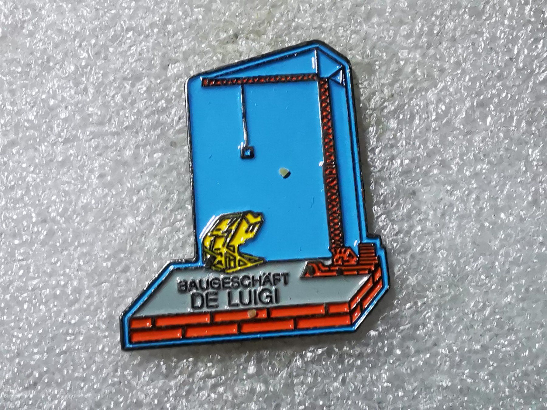 Placchette & Badge: Ansteckpin 79: Baugeschäft de Luigi – Usato da Oppligen venduto da Pin-Fall-Shop