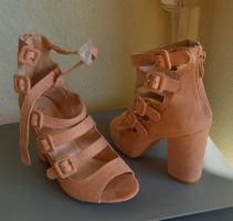 Chaussures roses à boucles et fermeture éclair.