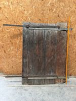Alte Holztür mit Beschlägen und Riegel abgebildet