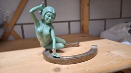 Glücksbringer. Broncestatue auf Hufeisen.